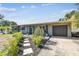 Charming single-story home featuring a well-maintained yard and attached garage with mature landscaping at 4610 W Mcelroy Ave, Tampa, FL 33611