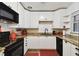 Charming kitchen with white cabinets, granite countertops, and black appliances at 4610 W Mcelroy Ave, Tampa, FL 33611