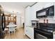 Kitchen with white cabinets, black appliances, and an adjacent dining area at 4610 W Mcelroy Ave, Tampa, FL 33611