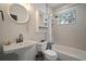 Well-lit bathroom featuring a classic pedestal sink, patterned tile, and a shower with a bathtub at 4803 Highland, Tampa, FL 33603