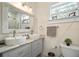 Bathroom featuring dual sinks, gray cabinets, marble countertops, modern fixtures, and an adjacent tiled shower at 4803 Highland, Tampa, FL 33603