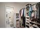 Walk-in closet featuring custom shelves, hanging rods, and organized storage with an adjacent view into the bathroom at 4803 Highland, Tampa, FL 33603