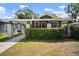 Charming bungalow featuring a cozy front porch, brick pillars and lush green hedge at 4803 Highland, Tampa, FL 33603