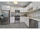 Bright kitchen boasts stainless appliances, white cabinets, patterned floors, and marble-style counters at 4803 Highland, Tampa, FL 33603