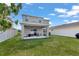 Green backyard with a covered patio and white fence, offering privacy and space at 5068 Little Stream Ln, Wesley Chapel, FL 33545