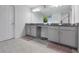 Bathroom featuring double sinks, gray countertops, ample storage space, and a tiled shower with glass doors at 5068 Little Stream Ln, Wesley Chapel, FL 33545