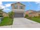 Two-story home with a two-car garage, neutral paint, minimalist landscaping, and shutters on the upper windows at 5068 Little Stream Ln, Wesley Chapel, FL 33545