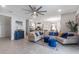 Open-concept living room with tile floors, neutral decor, and seamless flow to the kitchen and dining areas at 5068 Little Stream Ln, Wesley Chapel, FL 33545