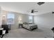The spacious bedroom features a ceiling fan, plush carpet and two windows at 5068 Little Stream Ln, Wesley Chapel, FL 33545