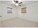 Inviting bedroom featuring a ceiling fan, two windows with blinds, and tile flooring at 5245 3Rd N Ave, St Petersburg, FL 33710