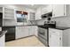 Bright kitchen features white cabinets, stainless steel appliances, and tile flooring at 5245 3Rd N Ave, St Petersburg, FL 33710