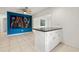 Living area with tile floors, custom wall art, and an adjacent kitchen at 5245 3Rd N Ave, St Petersburg, FL 33710