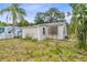 View of fenced backyard and rear of tan home, showing the home's corner at 536 Braddock S St, St Petersburg, FL 33707