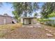 Backyard showing the rear of a tan house with an open back porch and a detached garage at 536 Braddock S St, St Petersburg, FL 33707