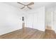 Bedroom with wood-look flooring, white walls, ceiling fan and doors to other rooms and closets at 536 Braddock S St, St Petersburg, FL 33707