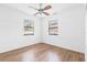 Bedroom featuring wood-look flooring, white walls and ceiling fan with natural light from two windows at 536 Braddock S St, St Petersburg, FL 33707