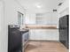 Kitchen with white cabinets, black appliances, wood countertops and modern wood-look flooring at 536 Braddock S St, St Petersburg, FL 33707