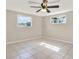 This bedroom is bright with its two windows and light tile floors at 6017 6Th Ave, New Port Richey, FL 34653