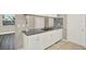 Open kitchen with granite countertops, white cabinets, stainless steel sink, and luxury vinyl plank flooring at 6017 6Th Ave, New Port Richey, FL 34653