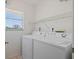 Efficient laundry room featuring a washer, dryer, and shelving with bright light at 6081 Bahia Del Mar Cir # 452, St Petersburg, FL 33715