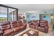 Spacious living room featuring leather sofas, dining area, and a large sliding door leading to balcony at 6287 Bahia Del Mar Cir # 404, St Petersburg, FL 33715