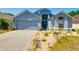 Charming single-Gathering home featuring a 2-car garage and beautifully landscaped front yard, complete with a welcoming wreath on the door at 7132 Colony Pointe Dr, Riverview, FL 33578