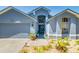 Charming exterior of the home featuring a two car garage and nice landscaping. A wreath hangs on the front door at 7132 Colony Pointe Dr, Riverview, FL 33578