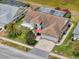 An aerial view of a home with lush landscaping, a brick driveway, and a red umbrella on the front porch at 9253 Water Hazard Dr, Hudson, FL 34667