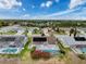 A wide aerial view of homes with solar panels, screened in pools, and lush landscaping against a bright blue sky at 9253 Water Hazard Dr, Hudson, FL 34667