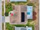Bird's eye view of property showcasing roof solar panels, manicured lawn, screened pool area, and surrounding neighborhood at 9253 Water Hazard Dr, Hudson, FL 34667