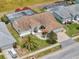 An aerial view of a home with mature landscaping, a red umbrella on the front porch and a screened-in pool in the backyard at 9253 Water Hazard Dr, Hudson, FL 34667