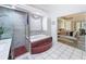 Bathroom featuring a tiled tub, a glass-enclosed shower, and an entry into an adjacent bedroom at 9253 Water Hazard Dr, Hudson, FL 34667