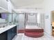 Bathroom featuring a tiled tub, a glass-enclosed shower, and a vanity at 9253 Water Hazard Dr, Hudson, FL 34667