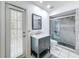 Bathroom featuring a new vanity, toilet, tiled shower, and access to an outside door at 9253 Water Hazard Dr, Hudson, FL 34667