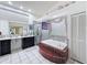 Bathroom featuring a tiled tub, a glass-enclosed shower, and double vanities at 9253 Water Hazard Dr, Hudson, FL 34667