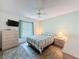 Bedroom with wood floors, ceiling fan, a neutral color scheme, and a flat screen TV at 9253 Water Hazard Dr, Hudson, FL 34667