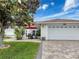 Charming home exterior with well-maintained lawn and outdoor seating under a red umbrella at 9253 Water Hazard Dr, Hudson, FL 34667