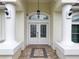 Close up of the front entrance of the house with double doors and decorative columns at 9253 Water Hazard Dr, Hudson, FL 34667