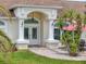 Elegant home entrance with double doors, decorative columns, and a beautifully paved walkway at 9253 Water Hazard Dr, Hudson, FL 34667