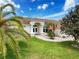 Inviting home exterior featuring lush green lawn, mature trees, and a welcoming front entrance at 9253 Water Hazard Dr, Hudson, FL 34667