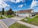 Home showcasing garage, brick-paved driveway and a well-maintained lawn at 9253 Water Hazard Dr, Hudson, FL 34667
