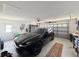 Spacious two-car garage with a black car parked inside, ample storage, and a clean, organized layout at 9253 Water Hazard Dr, Hudson, FL 34667