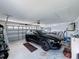 A well-organized two car garage featuring a sleek black vehicle, overhead storage, and a clean epoxy floor at 9253 Water Hazard Dr, Hudson, FL 34667
