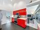 Bright kitchen features stainless steel appliances, modern red cabinets, granite countertops at 9253 Water Hazard Dr, Hudson, FL 34667