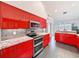 Bright kitchen features stainless steel appliances, modern red cabinets, granite countertops and double oven at 9253 Water Hazard Dr, Hudson, FL 34667