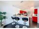 Bright kitchen features stainless steel appliances, black tile flooring, and red modern cabinets with barstool seating at 9253 Water Hazard Dr, Hudson, FL 34667