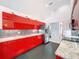 Bright kitchen features stainless steel appliances, modern red cabinets, and granite countertops at 9253 Water Hazard Dr, Hudson, FL 34667