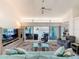 Bright living room featuring comfortable seating, a ceiling fan, and sliding glass doors to the pool area at 9253 Water Hazard Dr, Hudson, FL 34667