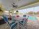 Outdoor patio with dining set, ceiling fan, and seating area overlooking the pool at 9253 Water Hazard Dr, Hudson, FL 34667