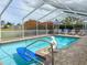 Spend your days in the screened pool and deck area with a mermaid statue and lush landscaping for tropical vibes at 9253 Water Hazard Dr, Hudson, FL 34667